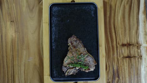 steak being placed and cooked on hot stone barbecue, overhead view