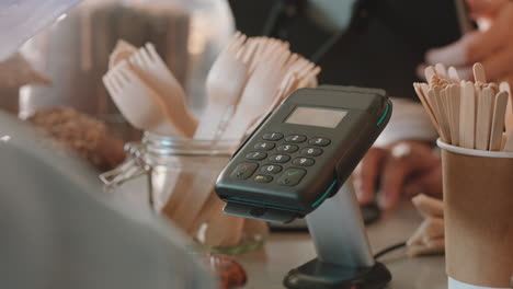 close up customer paying using credit card contactless payment spending money in cafe with digital transaction service