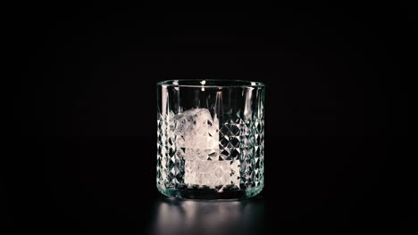 el cubo de hielo cae en un vaso vacío.