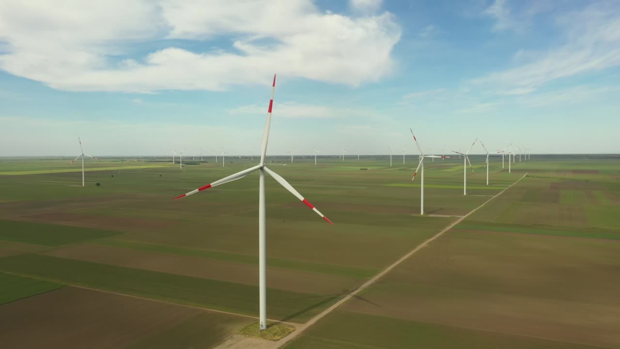 View of several windmills, wind generators, turbines, producing renewable clean energy by converting kinetic energy