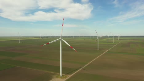 view of several windmills, wind generators, turbines, producing renewable clean energy by converting kinetic energy