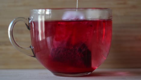 red tea being brewed in a glass cup