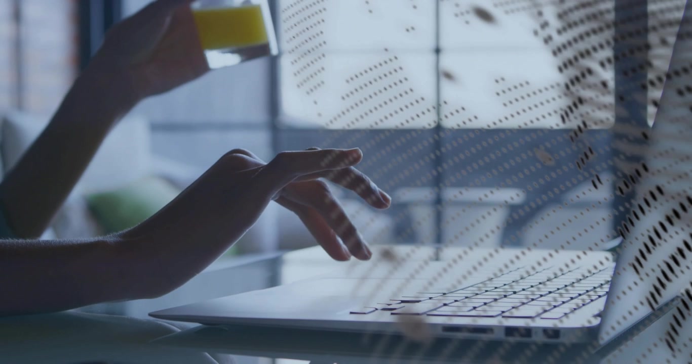 Right hand typing on laptop in tech visualizing dotted overlay shadowing and left lifting juice