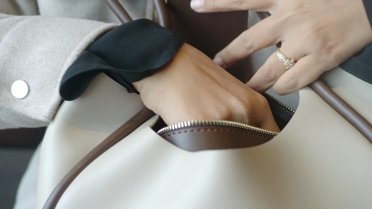 Hand reaching into handbag