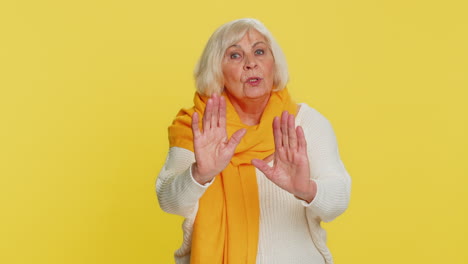 Strict senior woman warning hands gesture saying no be careful advice to avoid danger caution