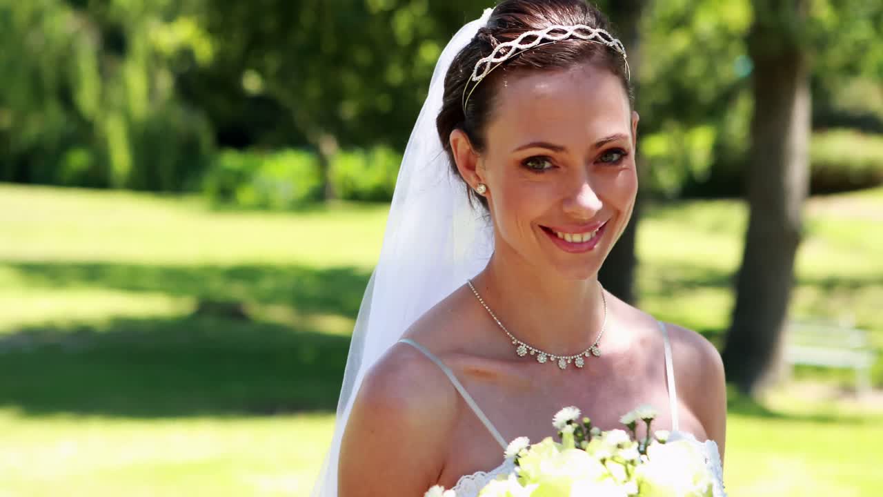 novia sonriente caminando hacia la cámara