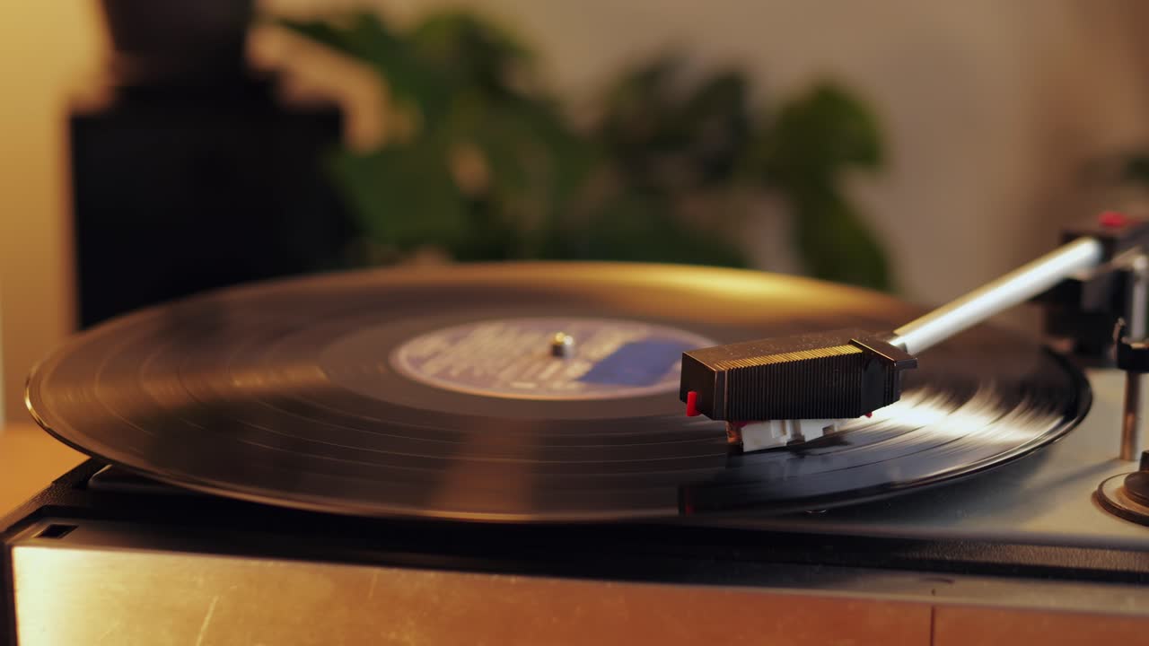 Retro Vinyl record player playing music, close-up macro shot of vintage LP disc old phonograph spinning. Retro music player.