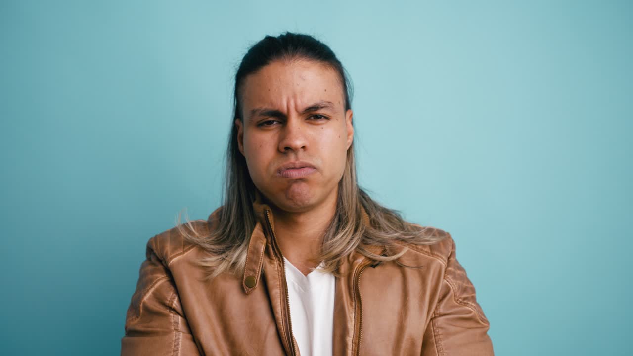 Hombre con expresión facial de disgusto sobre fondo azul