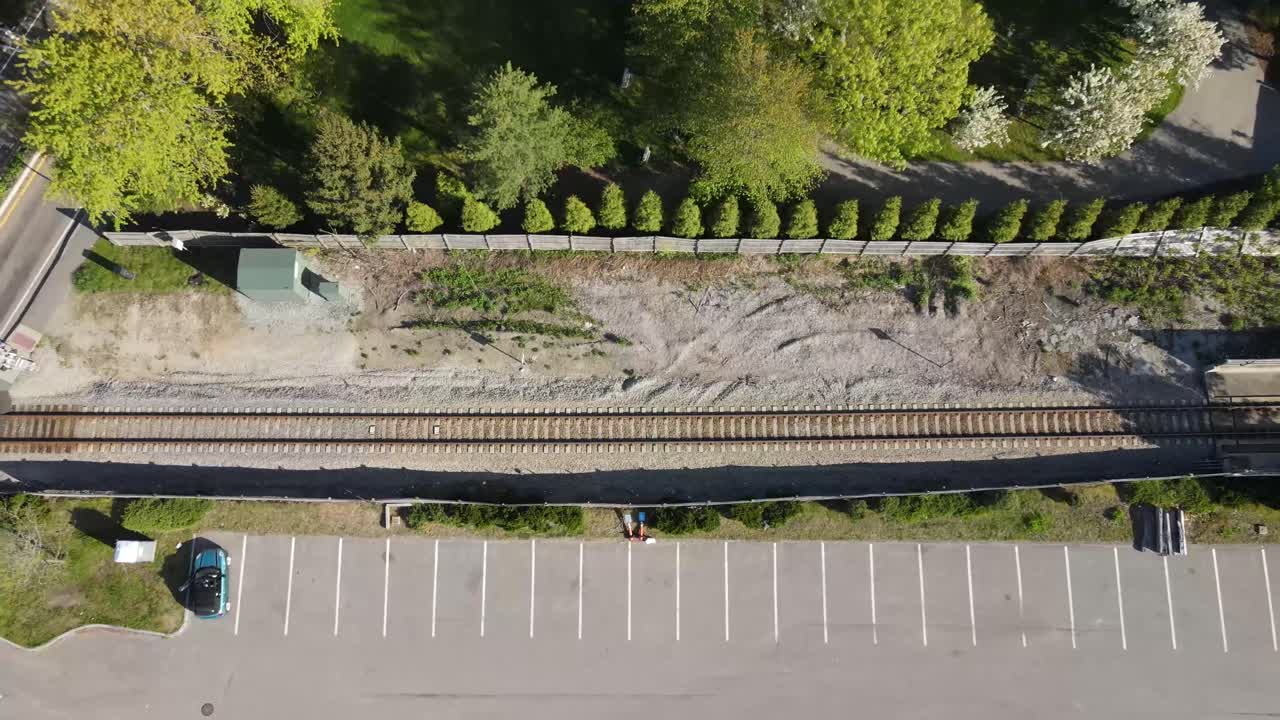 Ripresa aerea ascendente a volo d'uccello di un parcheggio e di un binario ferroviario, Massachusetts