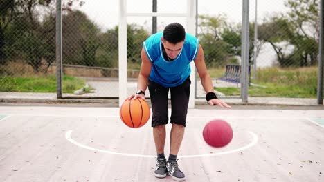 Nahaufnahme-Eines-Jungen-Mannes,-Der-Auf-Dem-Straßenplatz-Basketball-übt.-Er-Spielt-Mit-Zwei-Bällen-Gleichzeitig.-Zeitlupe