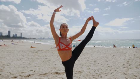 Yoga-Am-Strand-Im-Sommer---Flexibles-Mädchen,-Das-Vertikal-Stehende-Split-Pose-Macht---Baum-Pose-Zu-Halbgebundenem-Lotus,-Der-Nach-Vorne-Gebeugt-Am-Strand-Von-Burleigh-Heads-Steht