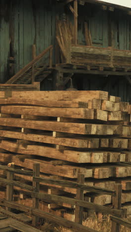 old wooden beams stacked by a rustic building