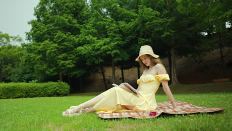 Young-woman-sitting-on-blanket-enjoy-a-picnic,-afternoon-of-reading-by-herself