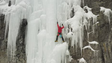 Escalador-De-Hielo-En-Cascada-De-Hielo-Congelado-Preparándose-Para-Subir-Maineline,-Monte-Kineo