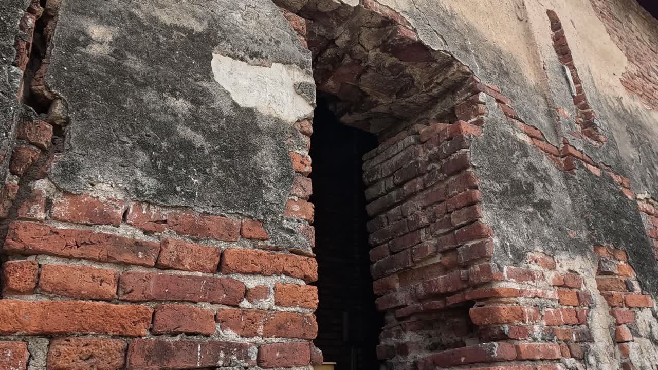 오래된 벽돌 벽의 손을 보여주는 시스