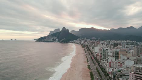 Aerial-view-establishing-dolly-in-from-the-beach-Leblon-Rio-de-Janeiro-Brazil,-Morro-Dois-Irmãos