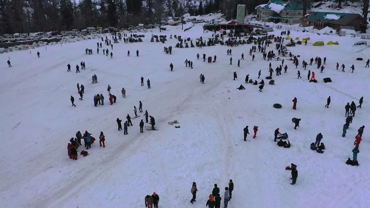 Aerial moving shot of a crowded snow valley at solang valley , himachal pradesh