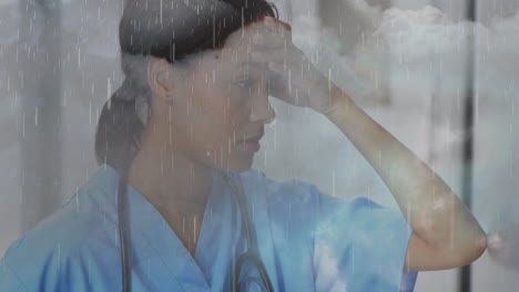 animation of clouds and rain over sad biracial female nurse in hospital