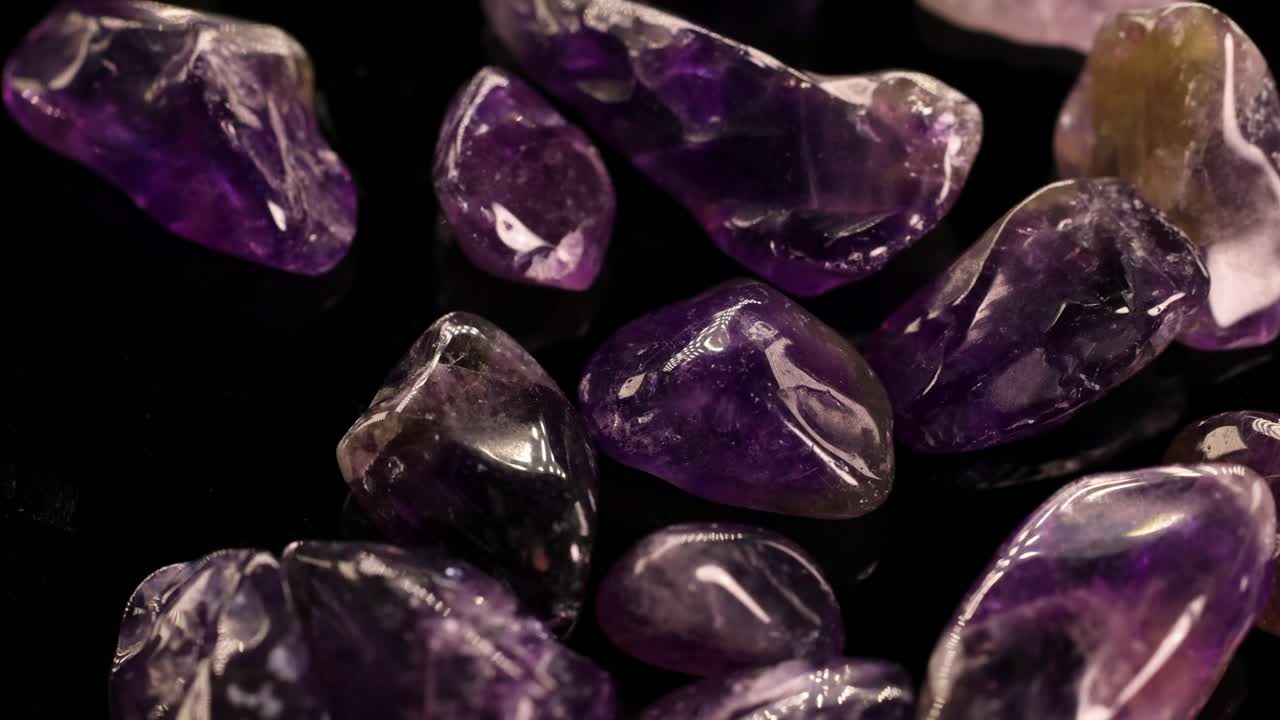 Amethyst stones glimmer under soft lighting, showcasing their vibrant purple hues and smooth textures in a dynamic close-up view