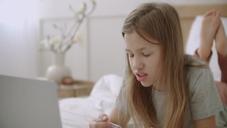 face of schoolgirl learning online thinking and answering on questions from home using video chat on notebook distant education and communication