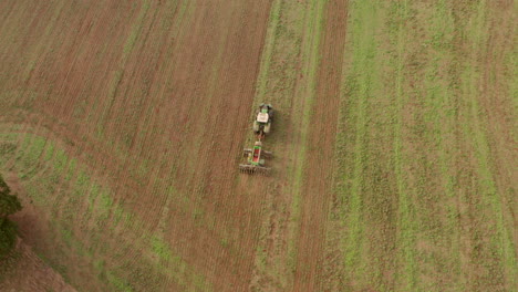 Schwenk-Luftaufnahme-Eines-Traktors,-Der-Ein-Feld-Pflügt