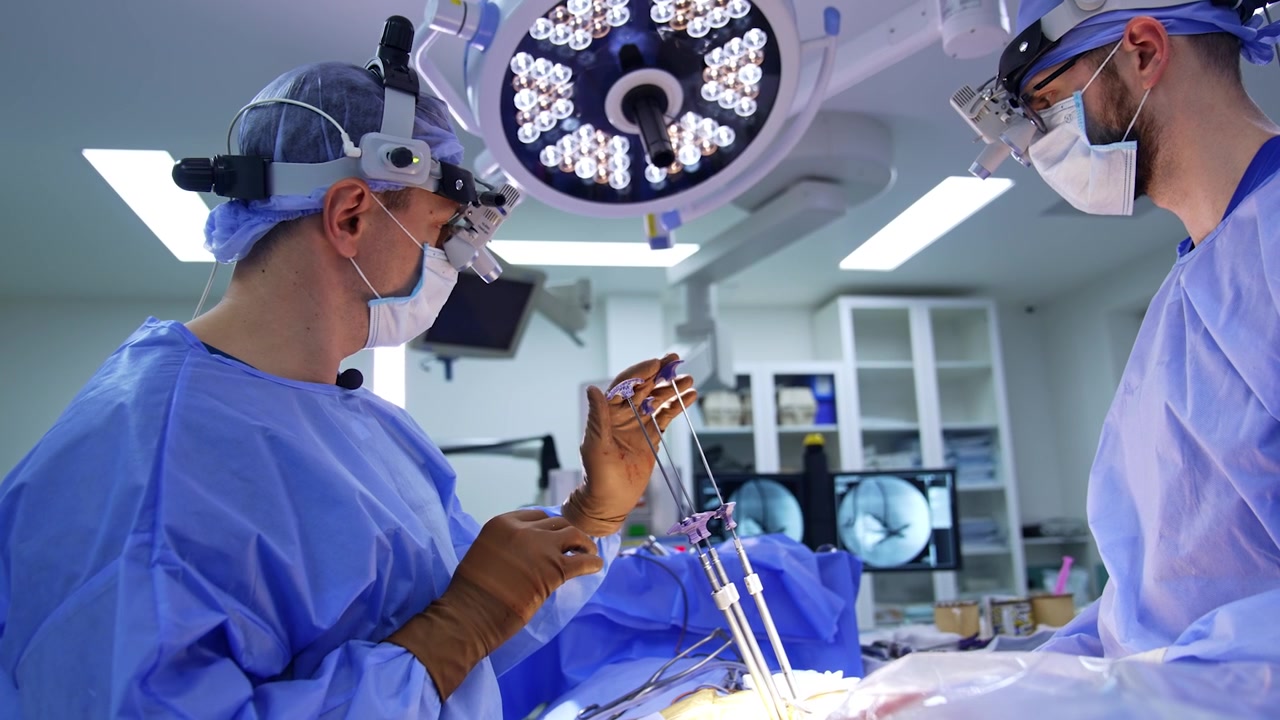 Doctor applies modern neurosurgical tools set on the patient's body. Surgeons wear loupes at operation.