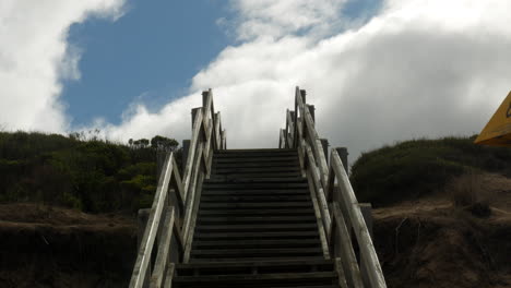 Clouds-and-blue-sky-scape-above-a-staircase-leading-down-to-an-Australian-beach