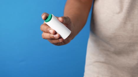 person holding a white medicine inhaler