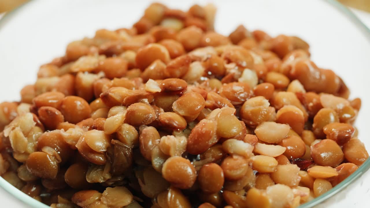 Lentils macro, Open metal can with preserved steamed brown lentils close up isolated on white background