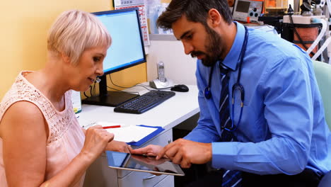 el médico discutiendo con el paciente a través de una tableta digital