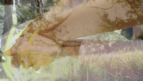 animation of a man washing his hands under a running tap at a sink over trees