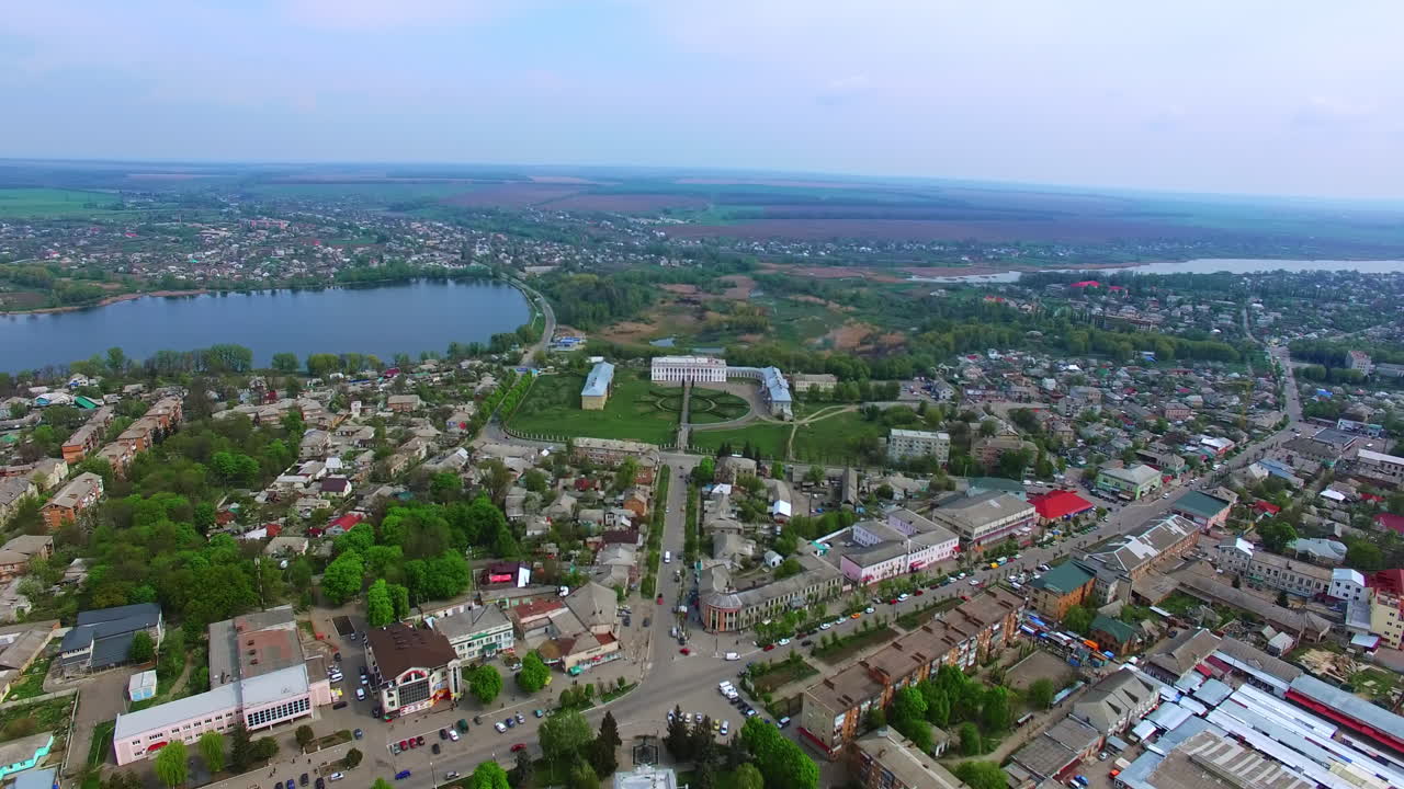 Scenery of the city with a pond in the middle. Approaching the historic ensemble of the palaces with flower-bed in the centre.