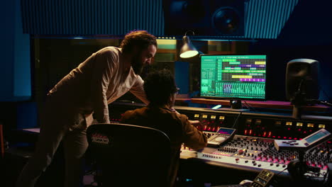 tracking engineer collaborating with musician to edit sounds in control room