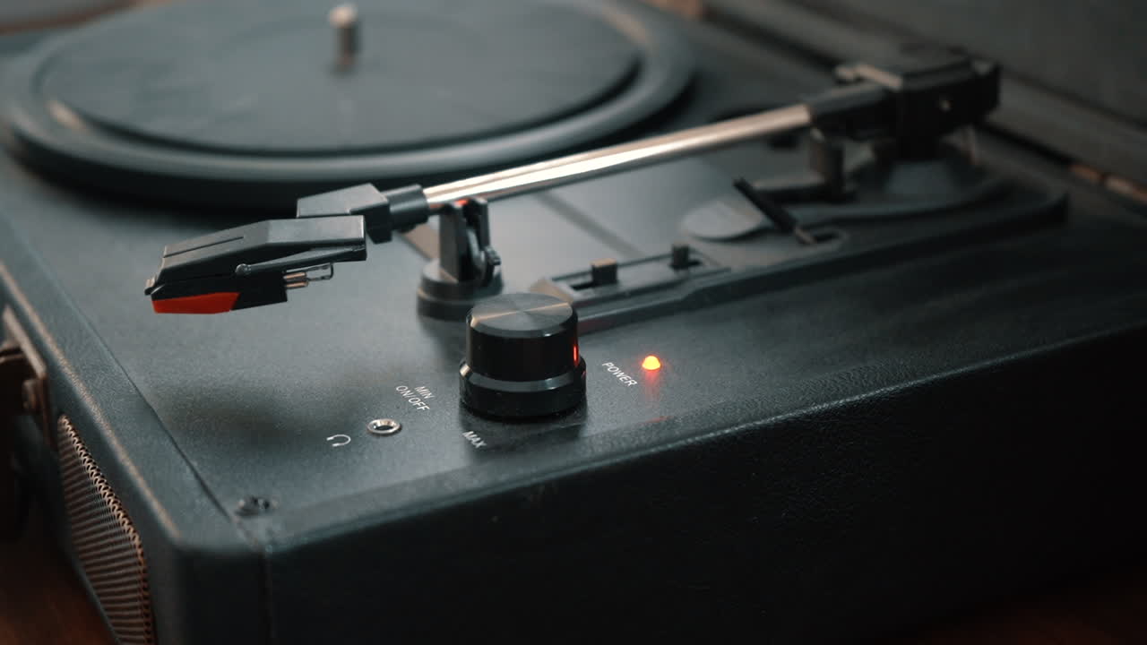 A hand turns off a turntable.
