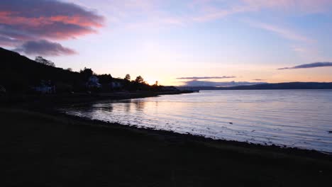 Hermosa-Puesta-De-Sol-Crepuscular-Sobre-El-Agua-Del-Océano-Y-La-Silueta-De-La-Costa-En-Lochranza-En-La-Isla-De-Arran,-Costa-Oeste-De-Escocia,-Reino-Unido