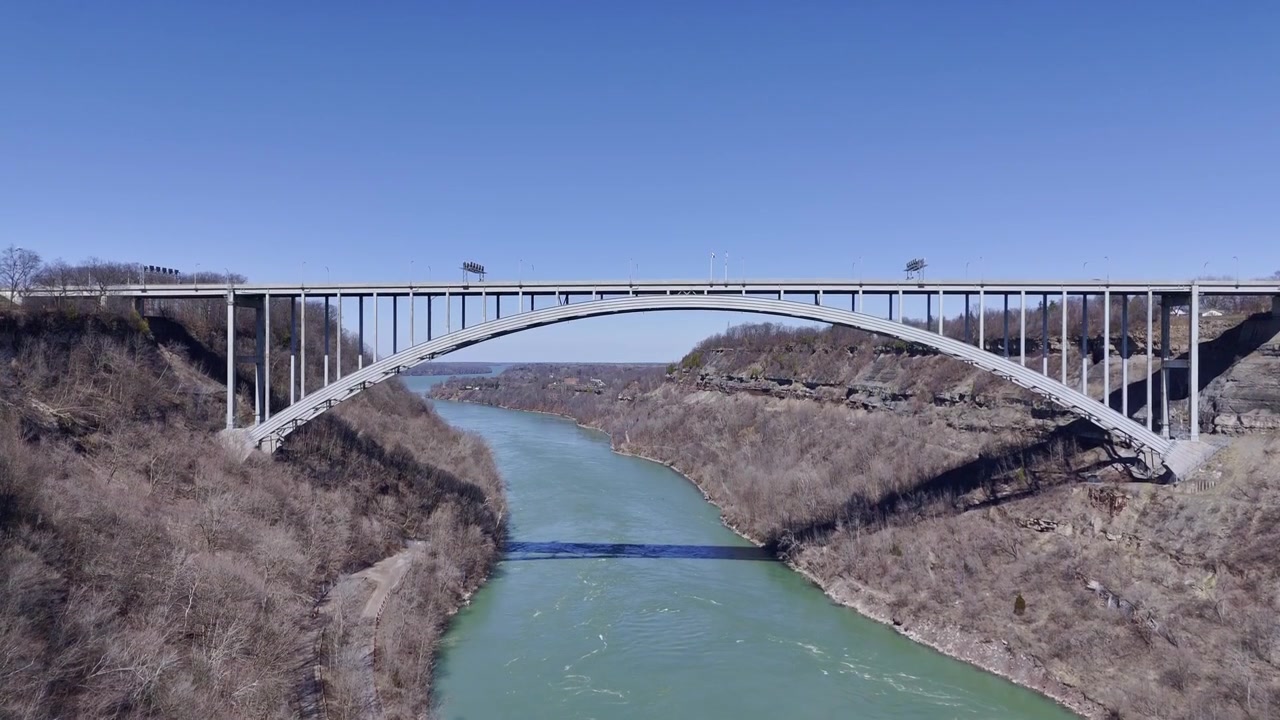Ontario, Kanada'da Niagara Nehri geçidini geçen Lewiston Queenston Köprüsü'nün devasa çelik kemer, derin vadi ve yukarıda berrak mavi gökyüzü içeren geniş manzaralı görünümü