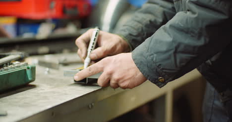 man working at metal industry cutting and measuring metal parts at workshop 4