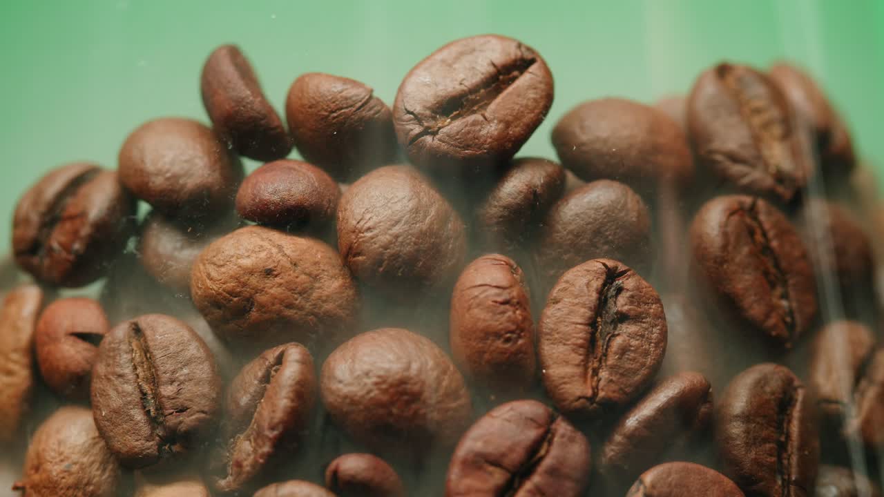 Close-up of Roasted Coffee Beans on Green Background