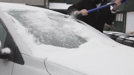 scraping off the thick ice on the car windshield - close up shot