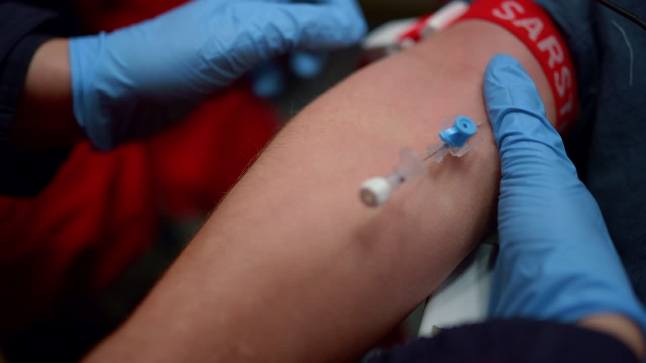 환자의 손에 투니켓을 벗고 있는 인식할 수 없는 구급대원