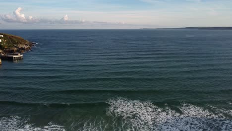 toma aérea de las olas que llegan a la orilla moviéndose hacia atrás en la playa de newquay, cornwall, inglaterra, reino unido