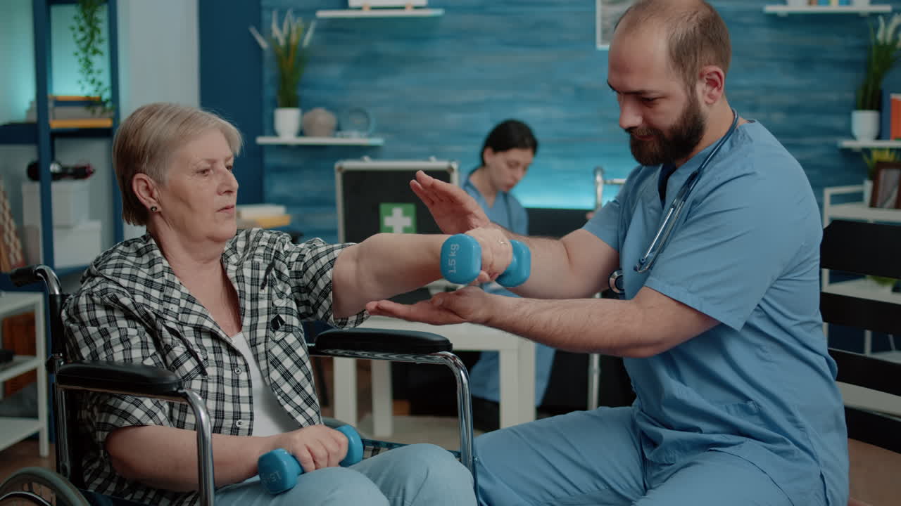 Medical assistant helping disabled woman with physical exercises