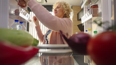 woman getting food from the refrigerator