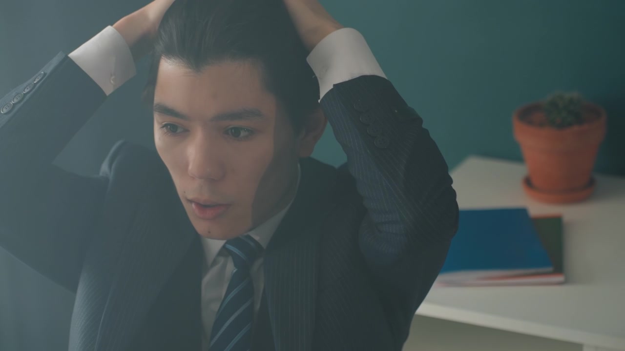 Asian businessman rubbing eyes showing fatigue, sit at desk with folders and plant, tie loosened, massaging temples and neck, eye strain and burnout relief, deep breath and composure, office pause