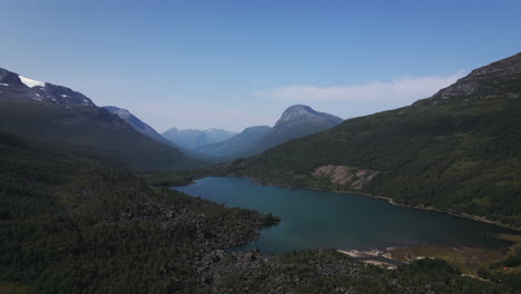Lago-Tranquilo-Rodeado-De-Montañas-Boscosas-En-Innerdalen,-Sunndal,-Noruega-Bajo-Un-Cielo-Azul