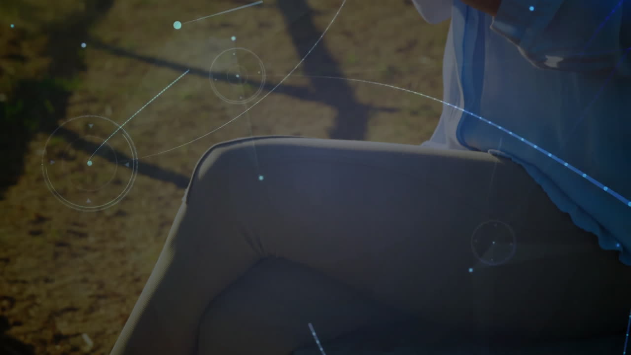 female doctor using medical smartphone sitting on outdoor bench, displaying animated network lines