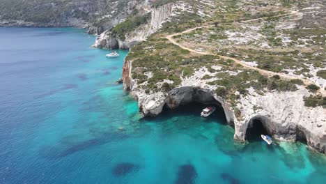 Tourist-boats-entering-the-Blue-Caves-in-Zakynthos-island,-Greece