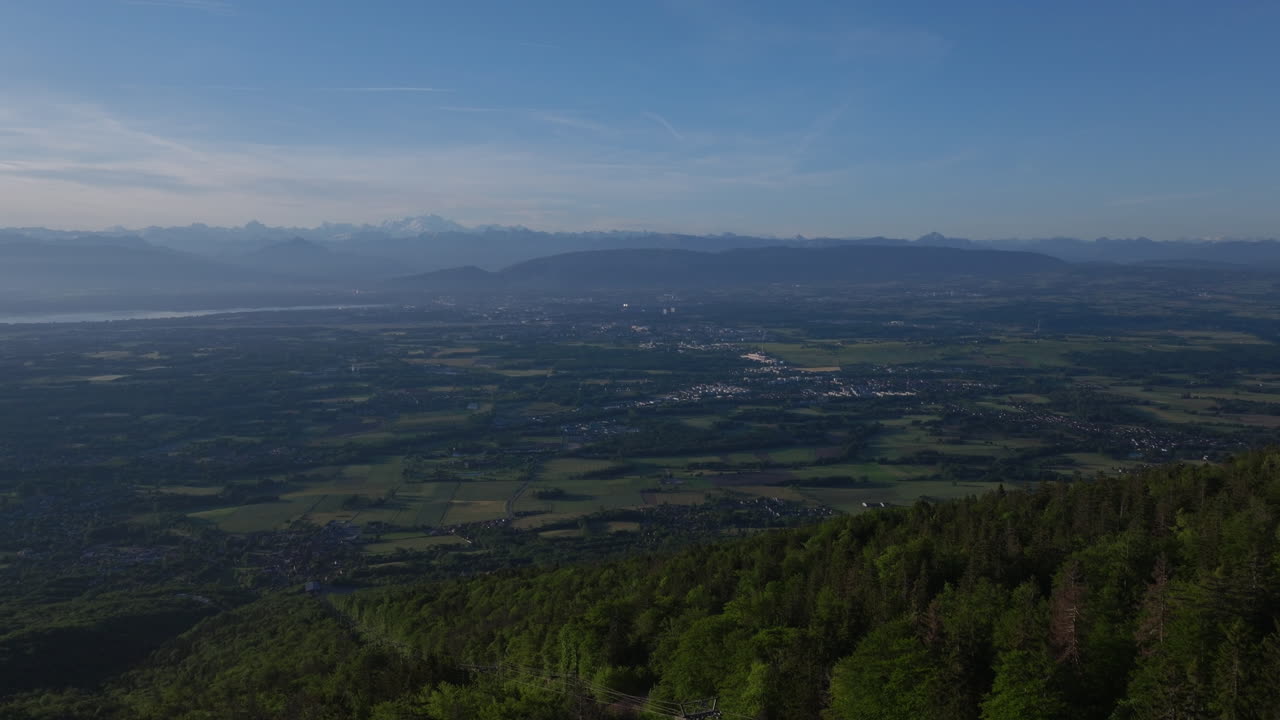 Aerial sunrise over Lake Geneva with fiery orange and red skies, panoramic Alpine views, and tranquil morning reflections on Lac Léman from the Jura.