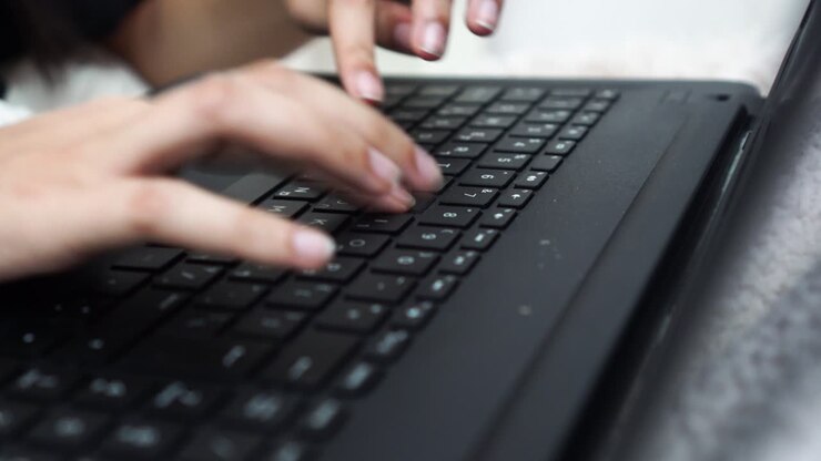 Girl's fingers type on a keyboard