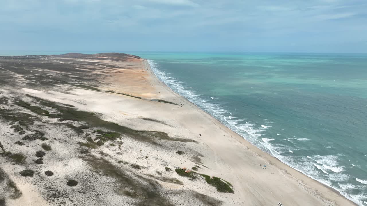 Jericoacoara beach, sea and sand dunes in Brazil, wide forward aerial